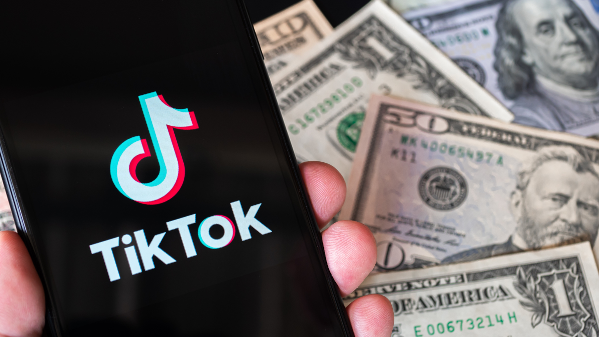TikTOK logo on a phone infront of $50 bills